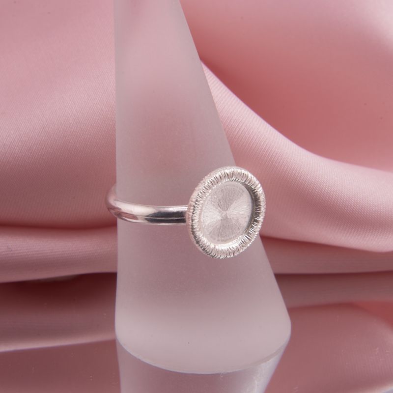 Preview: Nahaufnahme des Silberrings Coletta Facette aus 925 Silber präsentiert auf Ringständer, funkelnde Ronde und Halbrund Ringschiene.